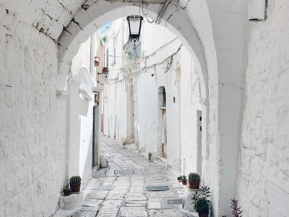 Vicolo bianco con arco nel centro storico di Ostuni